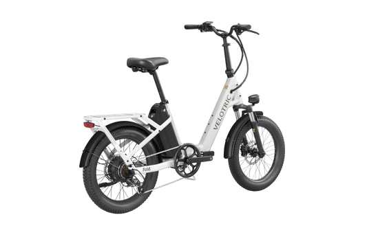 A compact, foldable Velotric Fold 1 eBike in matte black, shown fully assembled with upright handlebars and thick tires, positioned on a white background.