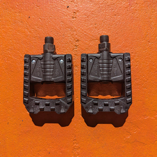 Black nylon folding style bicycle pedals, shown in a pair, designed for easy storage and transport.