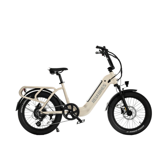 A white REVI Runabout 2 Step Thru electric bike with 20x3 fat tires, rear cargo rack, and 750w motor, shown from the side against a plain background.