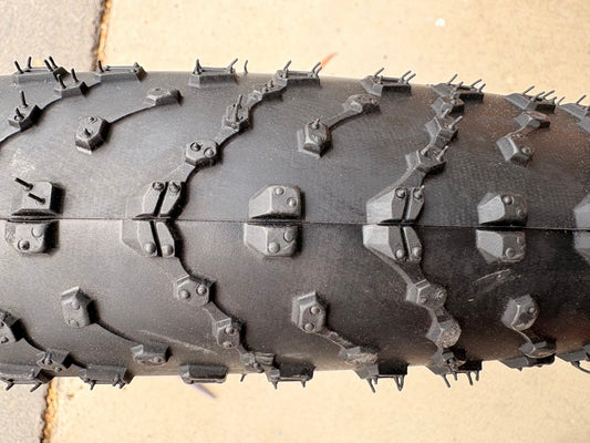 A black eBike with 26x4 inch Kenda Juggernaut fat tires, shown in a side profile against a white background.