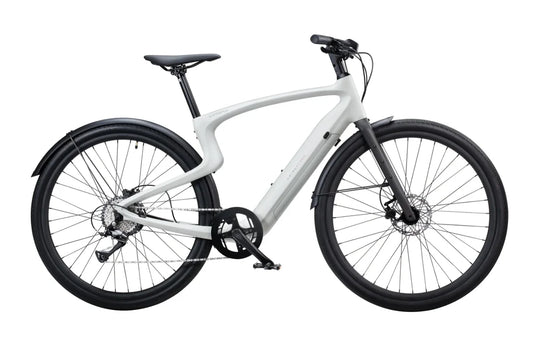 A creme-colored Urtopia Carbon 1 Pro eBike displayed from a side angle, showcasing its lightweight carbon frame, integrated battery, and sleek modern design.