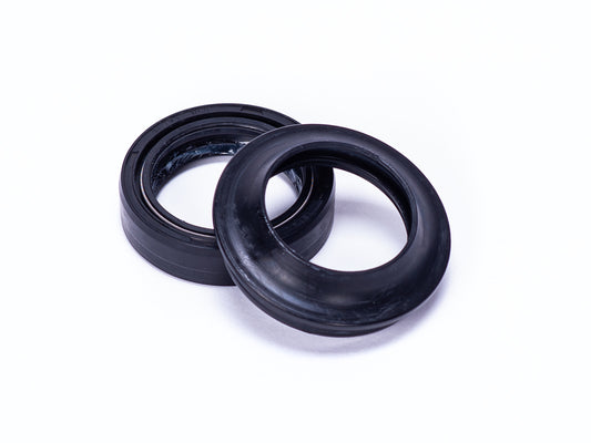 Close-up view of Stomp Ebox USD fork seals, showing two black rubber seals designed for motorcycle suspension maintenance.