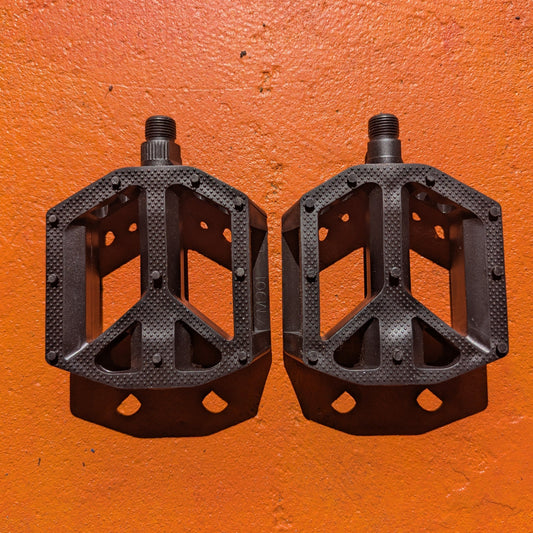 Black nylon eBike pedal with textured surface and reflective strip, shown from a side angle on a white background.