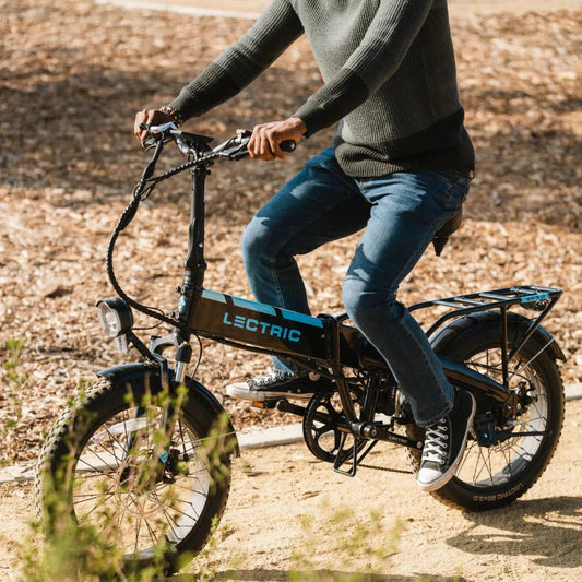 A black Lectric XP 3.0 folding fat tire eBike with a step-over frame, 500W motor, and commuter design, shown in a side profile view.