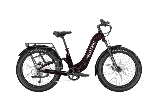 A Velotric Nomad 2X eBike in step-thru frame design, shown from the side with visible battery, wide tires, and upright handlebars.