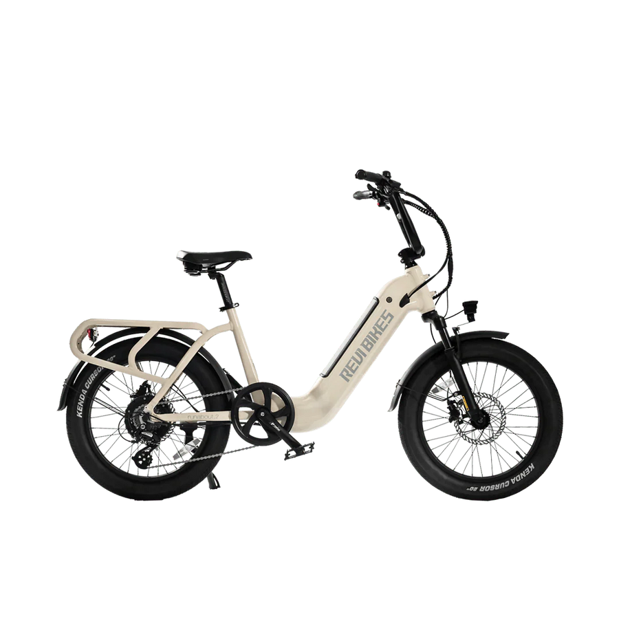 A white REVI Runabout 2 Step Thru electric bike with 20x3 fat tires, rear cargo rack, and 750w motor, shown from the side against a plain background.