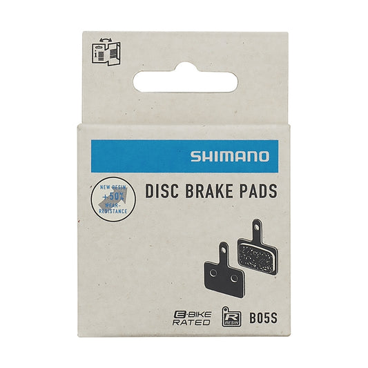 Shimano B05S resin brake pads for eBikes, shown front and back with metal backing plates and included spring.