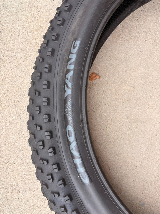 A black eBike with 26x4 inch Chao Yang fat tires, shown from a side angle against a white background.