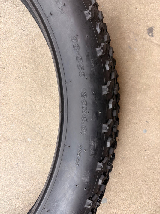A black eBike with 26x4 inch Kenda Krusade fat tires, shown in a side profile against a plain background.