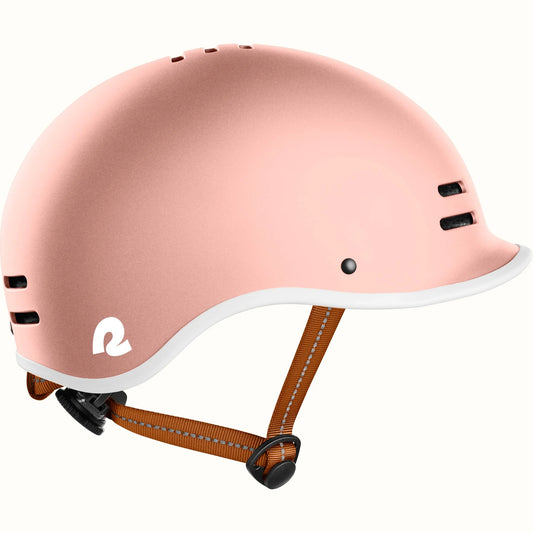 Rose gold Retrospec Remi eBike helmet, side view, with adjustable straps and ventilation holes