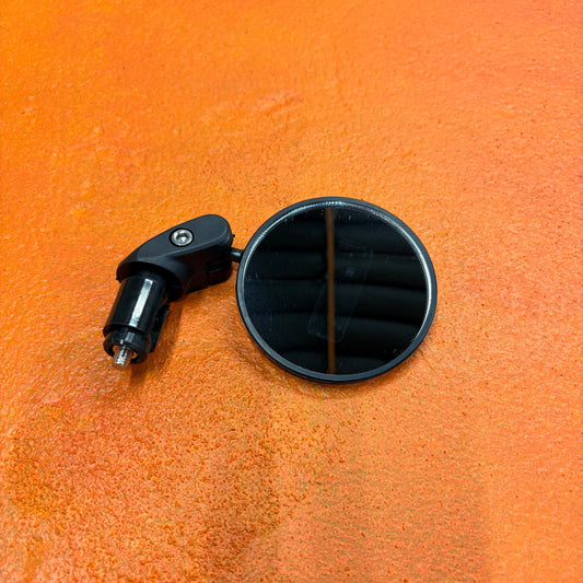 A close-up image of an eBike handlebar with a mounted rearview mirror, showing the mirror's adjustable arm and reflective surface.