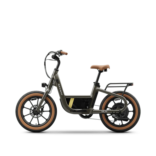 Olive green Segway Muxi eBike, side view, parked on a paved surface with a blurred outdoor background.