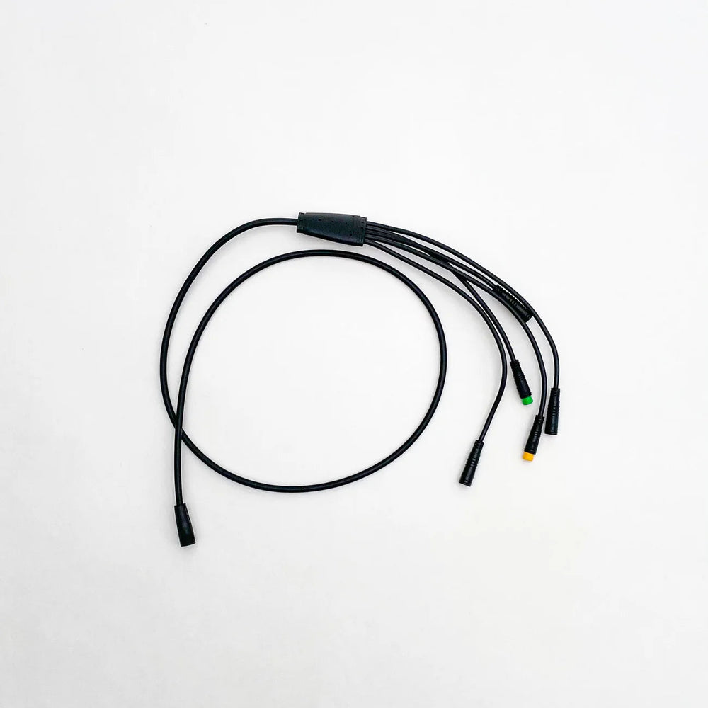 Close-up view of a Super73 R/RX/S2 e-bike wiring harness, showing multiple colored wires, connectors, and plugs arranged for electrical connections.