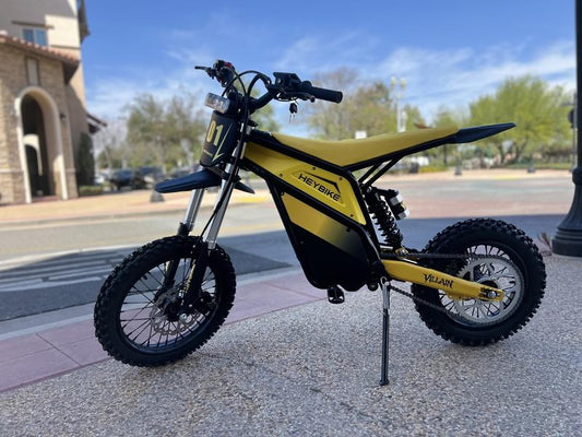 Electric motorcycle eMOTO Yozma Villain in a side view, showcasing its sleek black and red design, modern frame, and rugged tires.