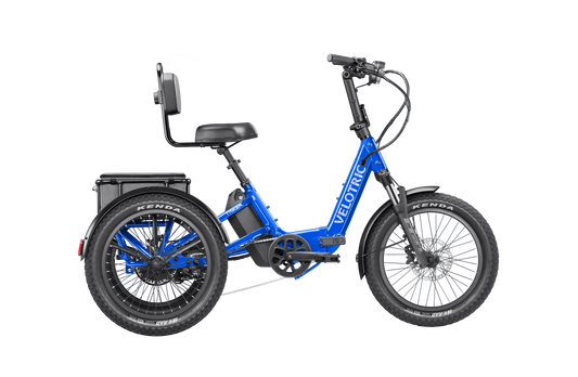 Electric blue Velotric Triker eTrike shown from side view, featuring three wheels, ergonomic seat, and modern frame design.