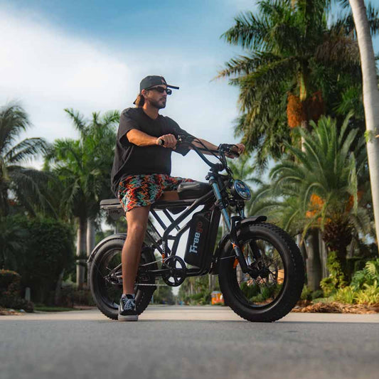 A black eMOTO FREEGO Shotgun Prime F2 Pro-Moto electric cargo eBike with a 1000W motor, shown from the side with a sturdy frame, wide tires, and rear cargo rack.