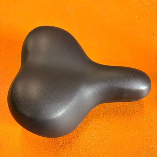 Black city-style eBike seat with ergonomic design and padded surface, shown from a side angle against a white background.