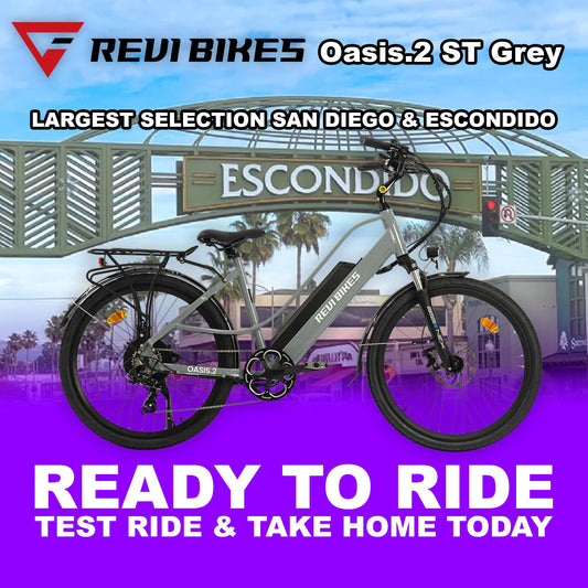 A group of people collaborating at a table with laptops and documents, discussing work in a modern office setting.