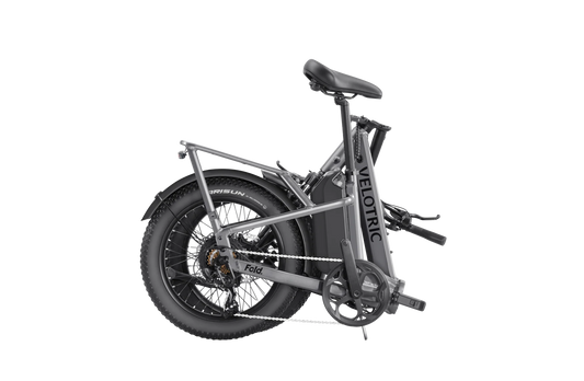 A black Velotric Fold 1 Plus electric folding bike shown from the side, with compact frame, thick tires, and integrated battery.