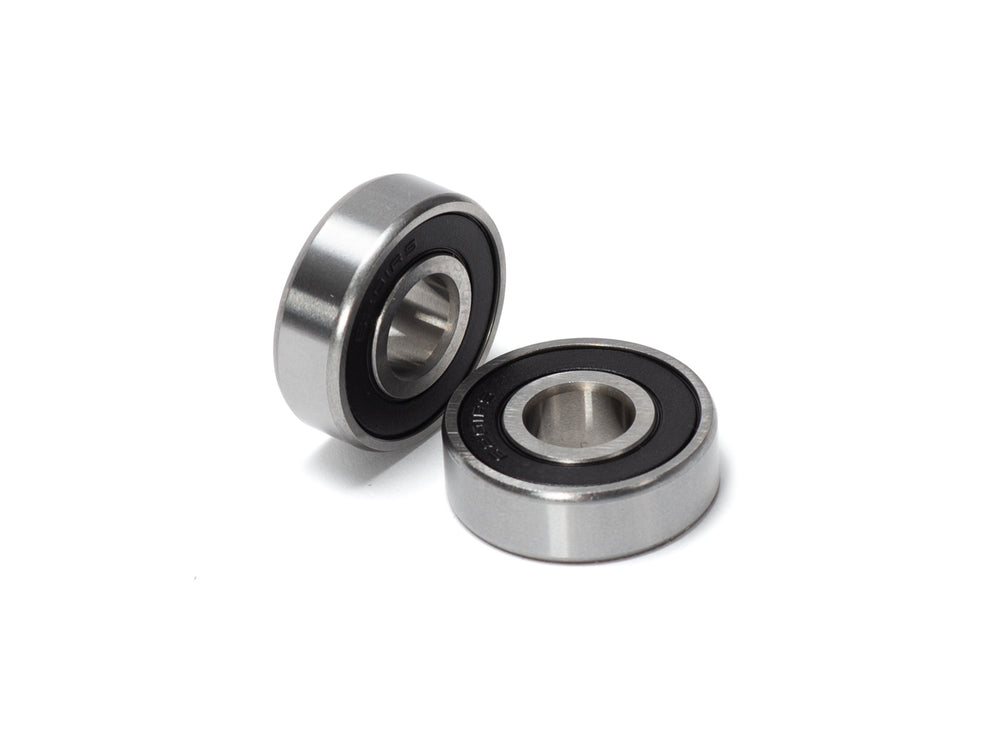 Close-up view of Stomp Ebox Dragster wheel bearings, showing two metal ball bearings on a white background.