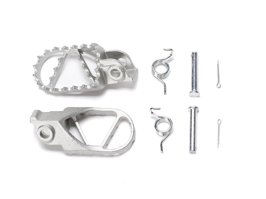Stomp Ebox stainless steel foot peg kit, showing two durable, textured metal foot pegs with mounting hardware on a white background.